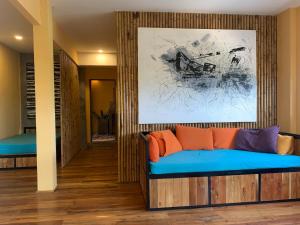 富國的住宿－Eco Lagoon，客厅配有蓝色沙发和绘画作品