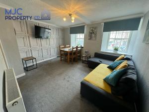 uma sala de estar com um sofá e uma mesa em Towerknowe em Hawick