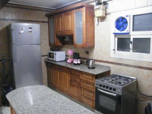 uma pequena cozinha com um frigorífico e um fogão em Mohandeseen apartment المهندسين عائلات em Cairo