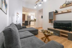 a living room with two couches and a flat screen tv at Lemon Tree House Varkiza in Vari