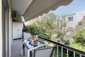 a balcony with a table with plates of food on it at Lemon Tree House Varkiza in Vari