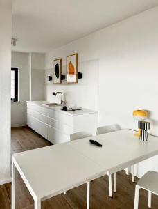 een witte keuken met een witte tafel en stoelen bij Apartments Hiper in Matulji