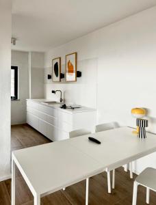 a white kitchen with a white table and chairs at Apartments Hiper in Matulji