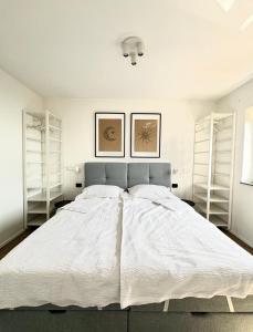 a bedroom with a large white bed with white walls at Apartments Hiper in Matulji