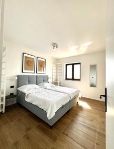 1 dormitorio con 1 cama grande y suelo de madera en Apartments Hiper, en Matulji