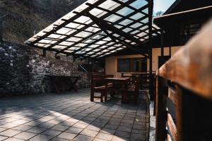 un patio al aire libre con mesa de madera y sillas en Pensiunea Casa Soarelui, en Podu Dîmboviţei