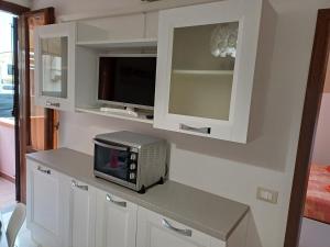 a kitchen with a microwave and a television on a counter at Azzurra in Marciana Marina