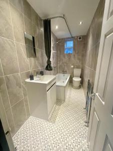 a bathroom with a sink and a toilet at Lovely Seaside Ground Floor Cottage Old Leigh in Leigh-on-Sea