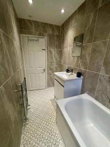 een badkamer met een bad, een toilet en een wastafel bij Lovely Seaside Ground Floor Cottage Old Leigh in Leigh-on-Sea