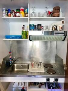 a kitchen with a sink and a stove and shelves at Domina coral bay resort direct beach and lake 1 in Sharm El Sheikh