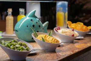 a table with bowls of food and chips and a vase at Sesimbra Oceanfront Hotel - Preferred Hotels and Resorts in Sesimbra