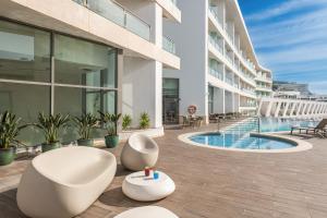 an exterior view of a building with a swimming pool at Sesimbra Oceanfront Hotel - Preferred Hotels and Resorts in Sesimbra