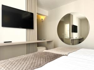 a bedroom with a large mirror and a bed at Hotel Marina in Izola