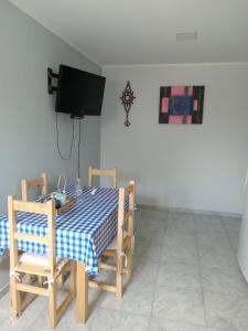 - une salle à manger avec une table, des chaises et une télévision dans l'établissement Del sur ., à Médanos