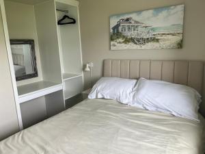 um quarto com uma cama e uma fotografia de uma praia em LA BELLA CHALETS 2 - 155 Sunbeach Holiday Village Scratby em Scratby