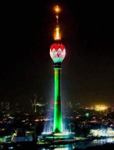 a green and red tower with a light at night at Ravan Holiday Inn in Trincomalee