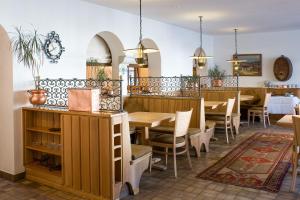 una sala da pranzo con tavoli e sedie in legno di Hotel Post a Bivio