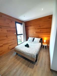 ein Schlafzimmer mit einem Bett mit einer Holzwand in der Unterkunft Sublime villa 9 pers- 5chb-pisicne-wifi in Le Poinçonnet