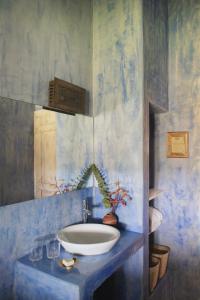 a bathroom with a sink and a blue wall at Muxima - Aljezur in Aljezur