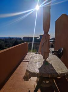 un tavolo su un balcone con il sole nel cielo di Casa Giulia a Saline Joniche
