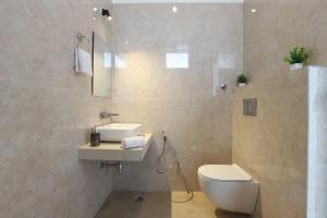 a bathroom with a white toilet and a sink at Edo Mansion By The Party Citadel - Luxury villa with pool, garden area, massive garden etc. in Jaipur