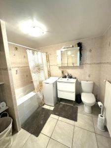 a bathroom with a toilet and a sink and a tub at T2 La roseraie in Chambéry