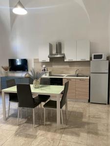 a kitchen with a table and chairs and a refrigerator at Mavi house in Catania