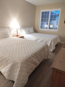 two white beds in a bedroom with a window at Pacific Plaza Resort in Oceano