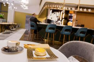 a table with a plate of food and a cup of coffee at Velero Hotel Doha Lusail in Doha