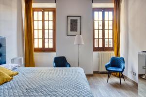 1 dormitorio con 1 cama y 2 sillas azules en URBANA 37 Maison, en Roma