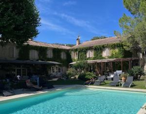 una casa con piscina en el patio en Logis Hôtel Restaurant La Sommellerie, en Châteauneuf-du-Pape