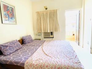 1 dormitorio con cama y ventana en Highland Beach Apartments Goa en Baga