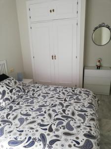 1 dormitorio con 1 cama con manta azul y blanca en APARTAMENTO EDIFICIO SEVILLA II, en Jerez de la Frontera