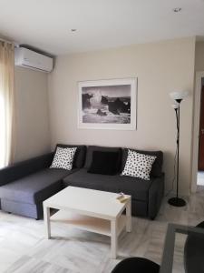 sala de estar con sofá y mesa de centro en APARTAMENTO EDIFICIO SEVILLA II, en Jerez de la Frontera