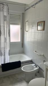 y baño con bañera, aseo y lavamanos. en APARTAMENTO EDIFICIO SEVILLA II, en Jerez de la Frontera