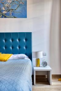 1 cama con cabecero azul y mesa con lámpara en URBANA 37 Maison, en Roma