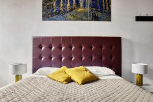 1 cama con cabecero morado y 2 almohadas amarillas en URBANA 37 Maison, en Roma