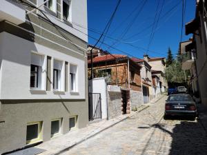 a street with a car parked on the side of a building at Travelers' Korça Home in Korçë