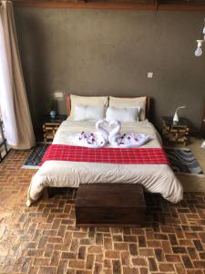 a bedroom with a bed with two towels on it at Mashambani Cottages in Nyahururu