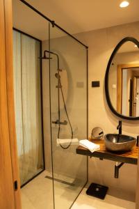 a bathroom with a shower with a sink and a mirror at Hotel 1920 in Podgorica