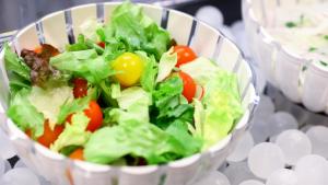 a salad in a white bowl with tomatoes and lettuce at Onyado Nono Sendai Natural Hot Spring in Sendai