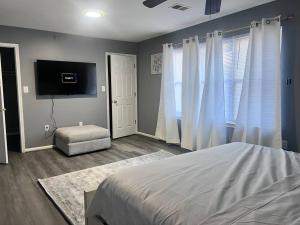 1 dormitorio con 1 cama y TV de pantalla plana en Urban 3bedroom Luxury beside Newark airport/Downtown newark, en Newark