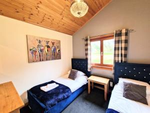 a bedroom with two beds and a window at Kingfisher Lodge-HuntersMoon -Warminster-Longleat-Bath in Warminster