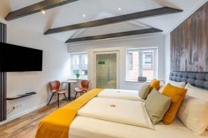 a bedroom with a large bed and a table at LÜTTES LOFT Boutique Hotel in Eckernförde