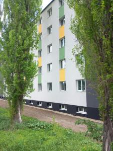 an apartment building with colorful windows and trees at Óbudai Diákszálló in Budapest