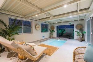 a swimming pool in a living room with chairs and a couch at Maki-Saki Boutique Self-Catering Accommodation in Yzerfontein