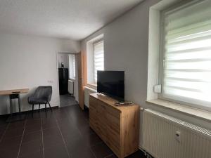 ein Wohnzimmer mit einem Flachbild-TV und einem Stuhl in der Unterkunft Ferienwohnung - Gästewohnung in Forst(Lausitz) in Forst