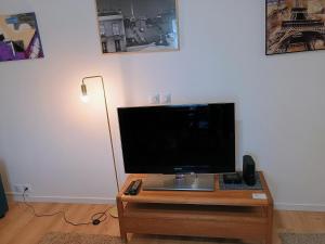 a flat screen tv sitting on top of a wooden table at Proche Paris,Cosy appartement, 3 bedrooms in Saint-Ouen