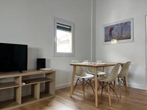 a living room with a dining room table and a television at Mon Residence Sant Jeroni in Manresa