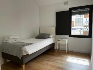 um pequeno quarto com uma cama e uma janela em Mon Residence Sant Jeroni em Manresa